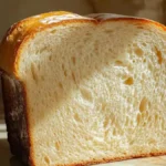 A golden-brown toasted slice of bread on a white ceramic plate