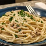 Ground chicken being cooked in a skillet for Alfredo pasta