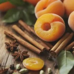 Fresh apricots and cinnamon sticks arranged on a rustic wooden table, perfect for dessert recipes or healthy snacks.