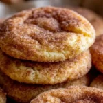 Close-up of stacked snickerdoodle cookies coated in cinnamon sugar, golden and soft